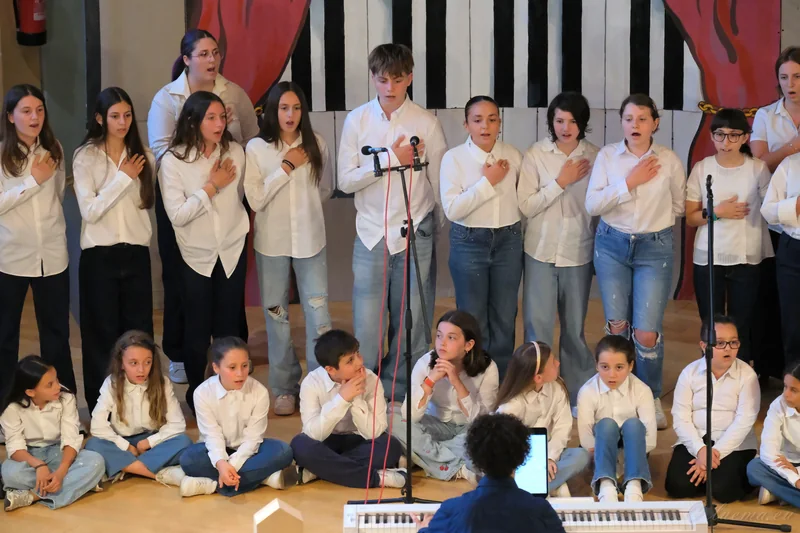 Cantori in piedi e seduti durante il concerto, con il direttore alla tastiera