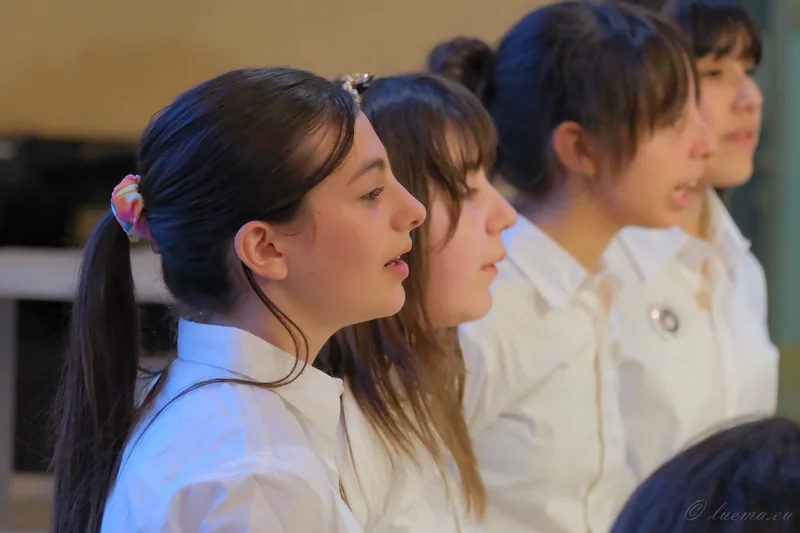 Una fila di cantori ripresa di profilo durante il canto