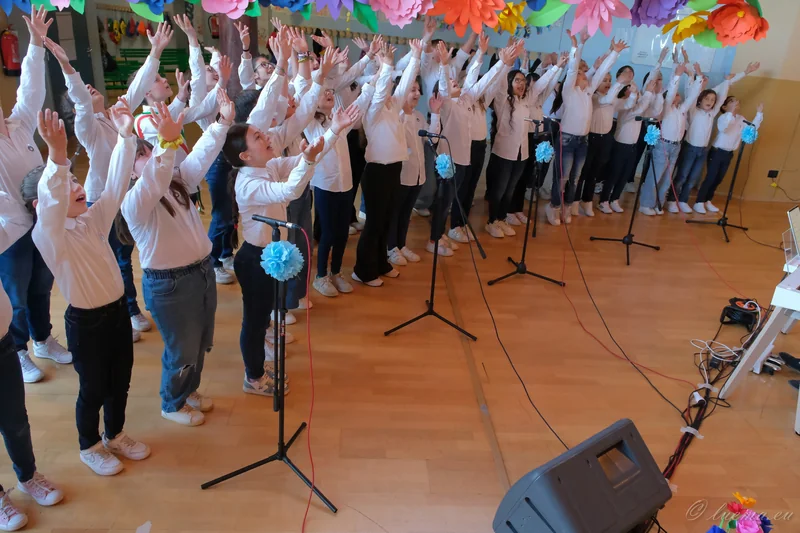 Il coro canta con le braccia alzate