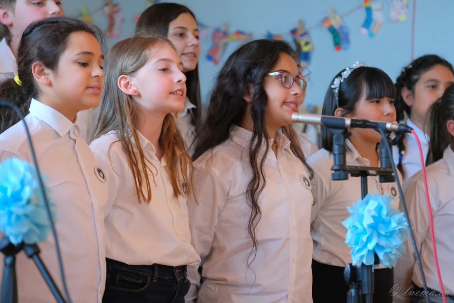 Cantori del coro durante il concerto, fra i fiori azzurri